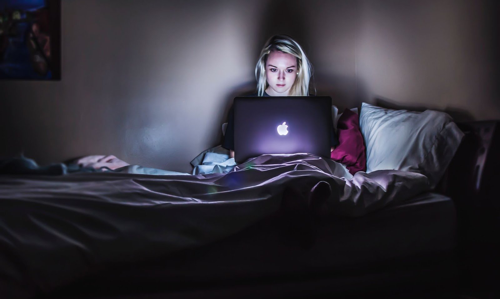 A woman working in bed at night