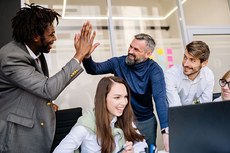 Motivated employees celebrating with a high five