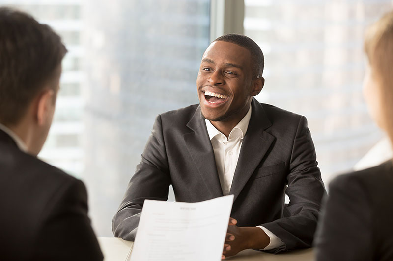 Job candidate smiling at a kind comment made during a job interview.