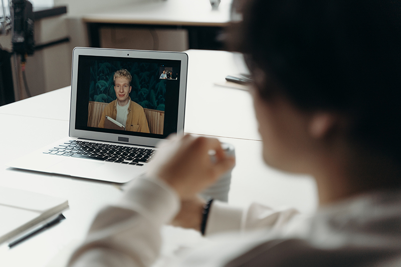 A person shown on a laptop screen as part of a video conferencing call.