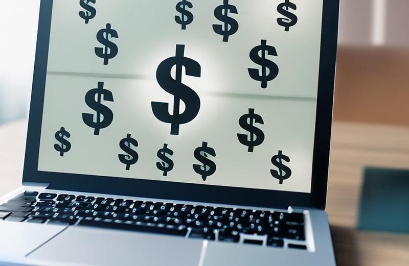 Laptop with dollar signs on the screen to signify the cost of an applicant tracking system.