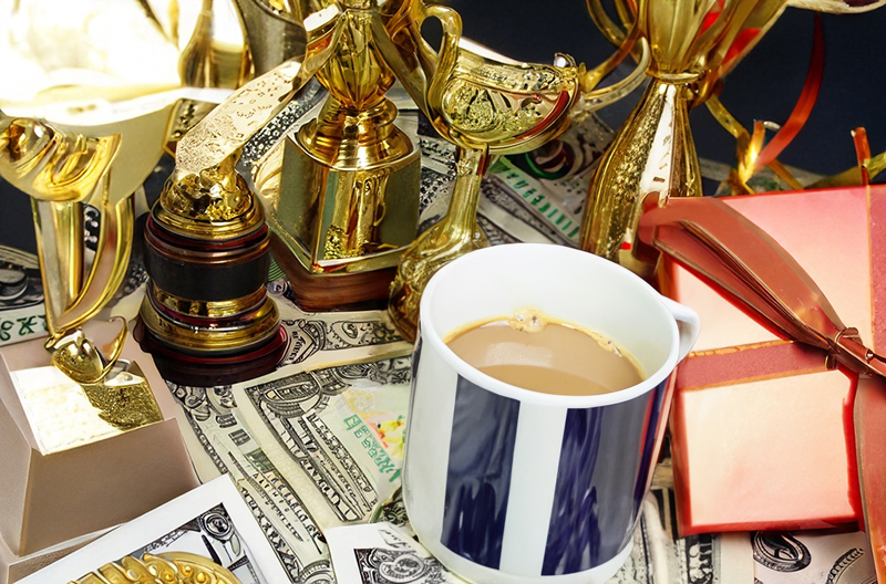 A selection of monetary and non-monetary rewards that can be given to employees as part of an employee rewards system including money, gifts, trophies, and coffee. 