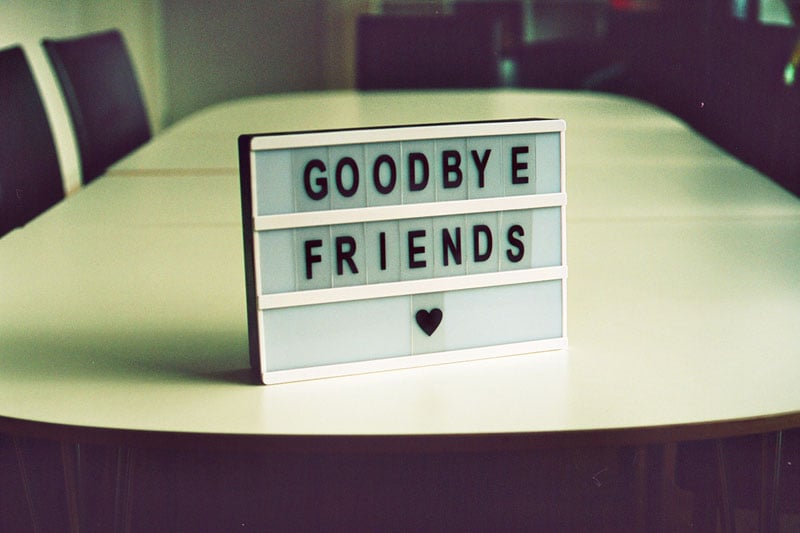 A small sign positioned on a large table showing a farewell message and a heart