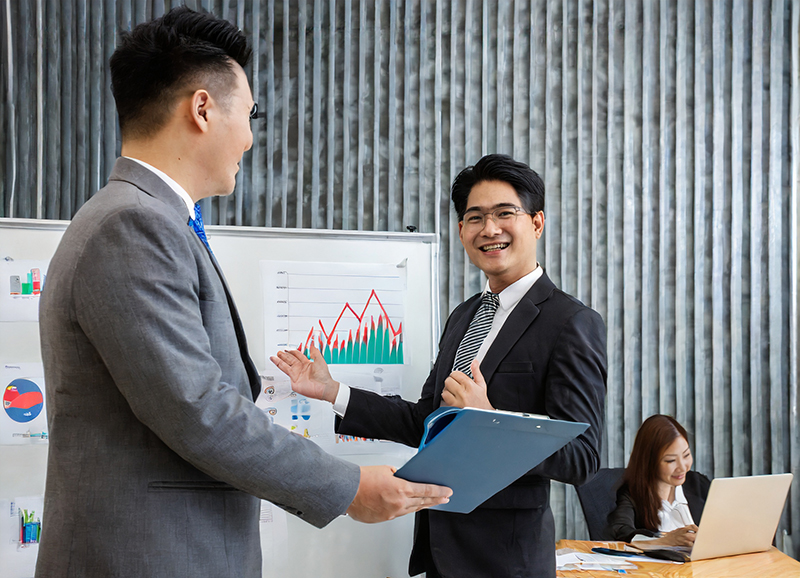 An employee receives a glowing performance review and a merit increase after a presentation where he shows graphs of positive organizational results.